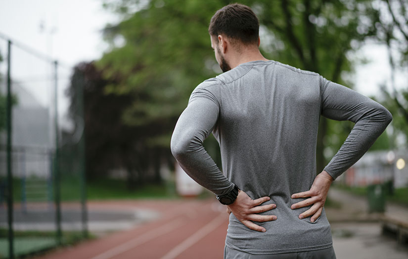 Sportsman suffering from backache at park outdoors