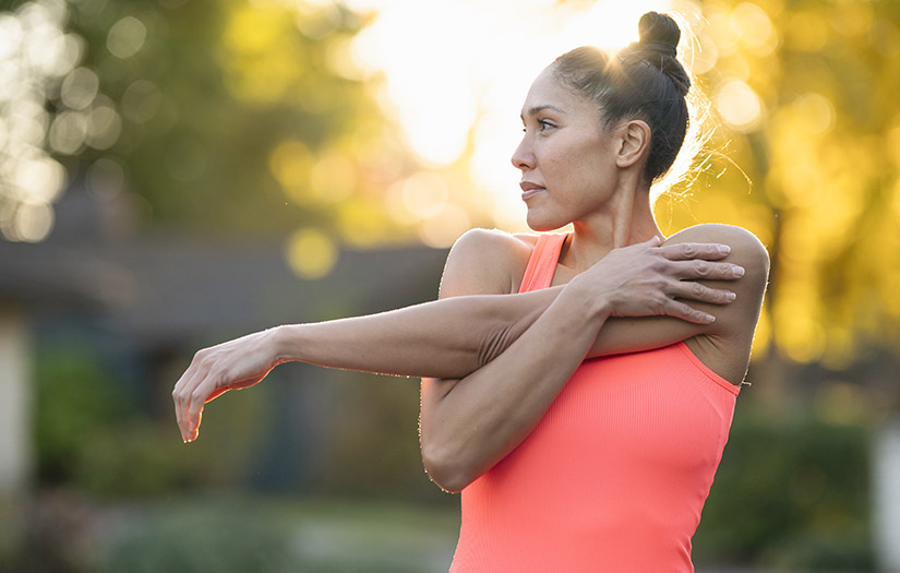 Beautiful female athlete stretching before outdoor workout